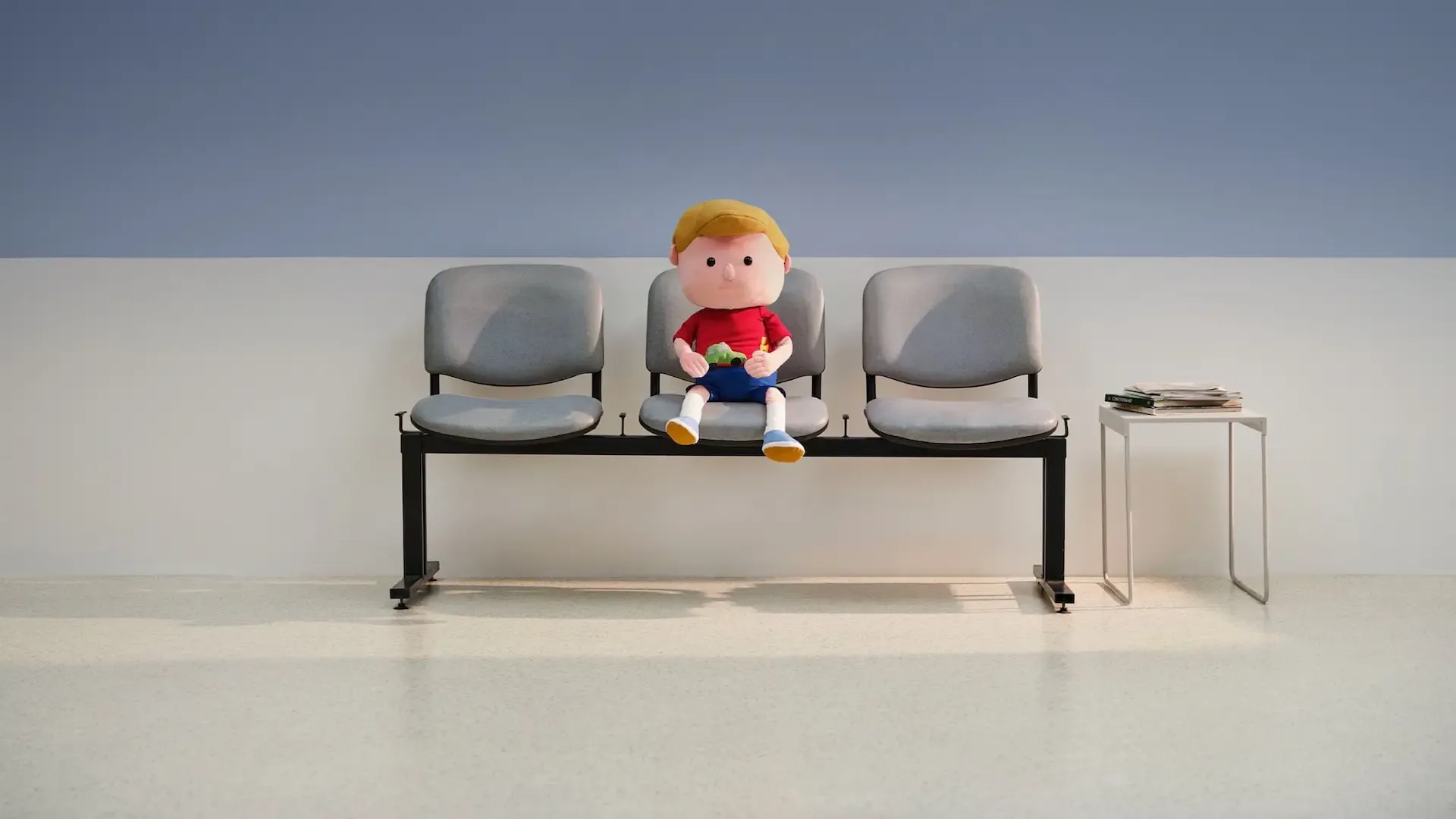 The doll of Ralph sitting on a bench